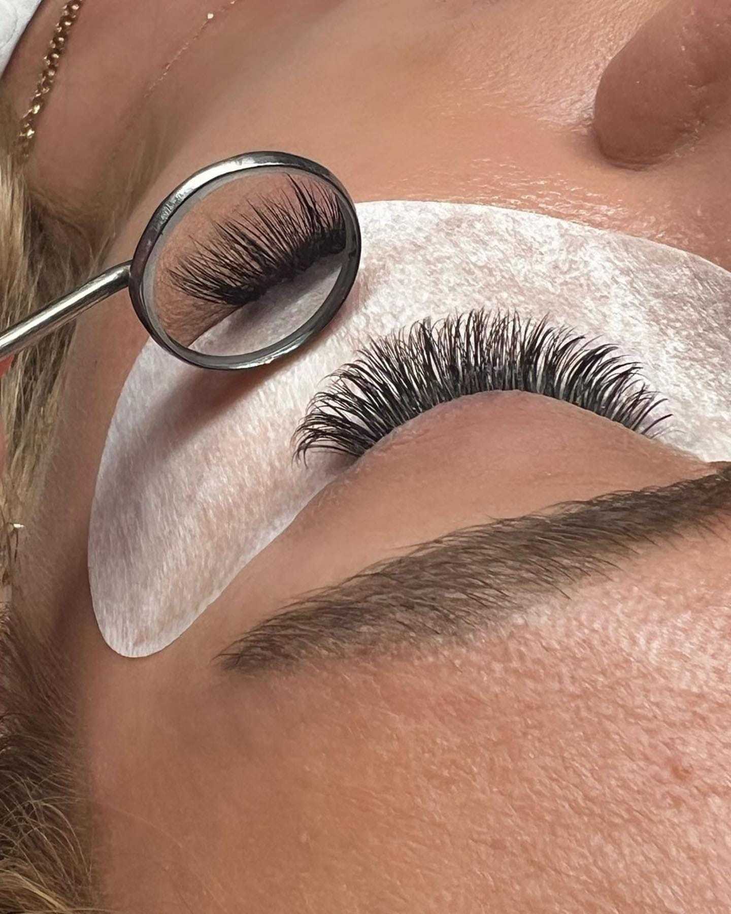 Eyelash extensions being applied, with a close-up of lashes under a magnifying glass.